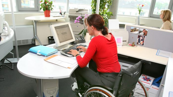 jeune femme handicapée sur son fauteuil dans un environnement de travail au bureau