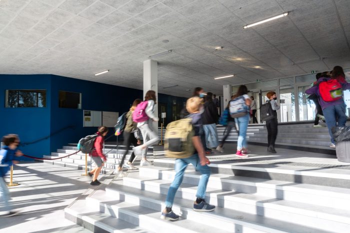 élèves pontant quatre à quatre les marches d'un lycée