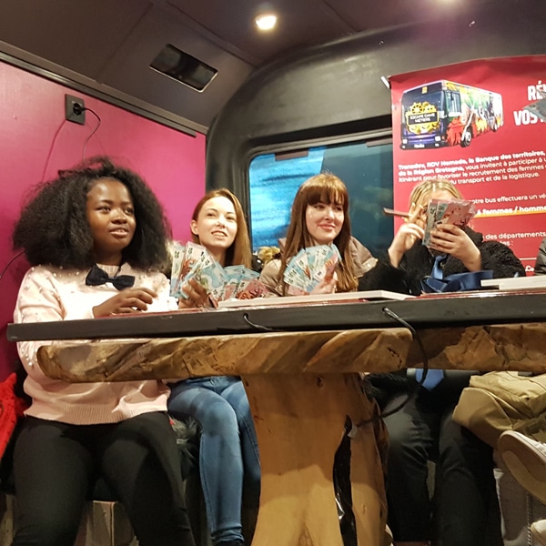 jeunes filles jouant autour d'un table dans le bus escape game de Transdev