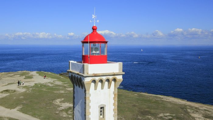 Phare rouge et blanc sur une falaise surplombant la mer