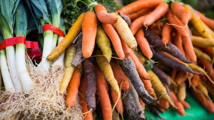 Étal de carottes et poireaux sur un marché en Bretagne