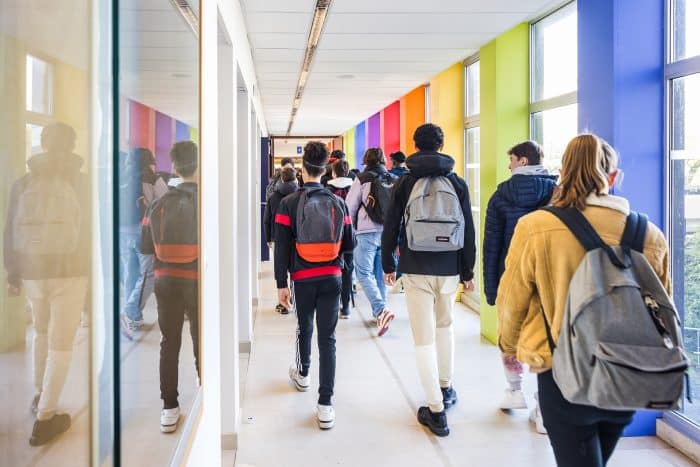 Lycéens marchant dans un couloir de lycée