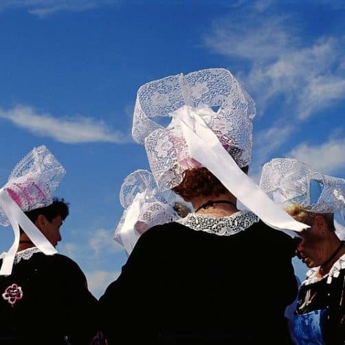 Des femmes de dos, coiffées de la coiffe bretonne