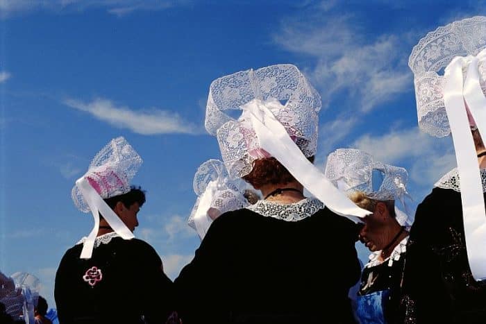 Des femmes de dos, coiffées de la coiffe bretonne