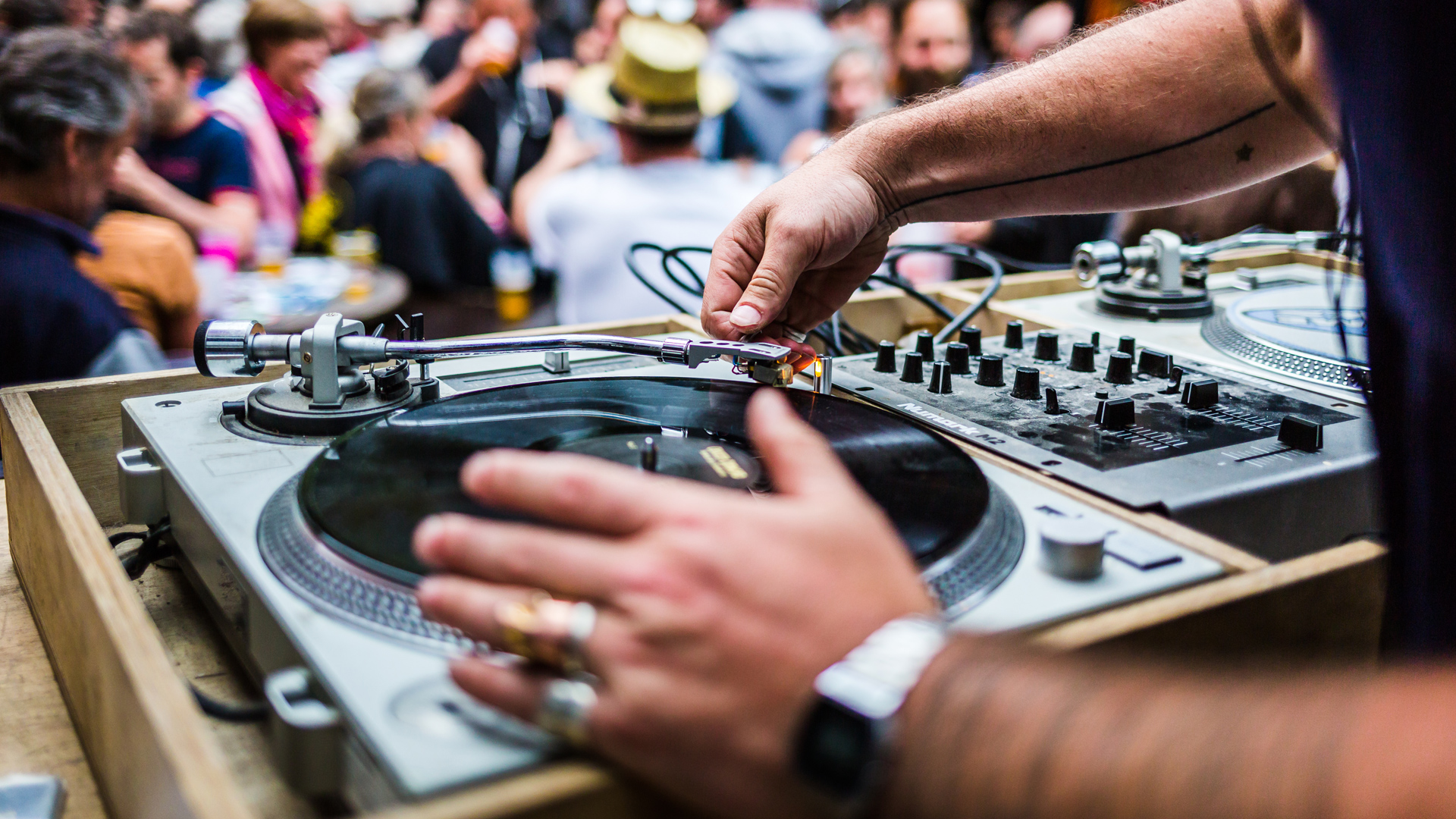 gros plan sur un DJ mettant un disque vinyle sur une platine