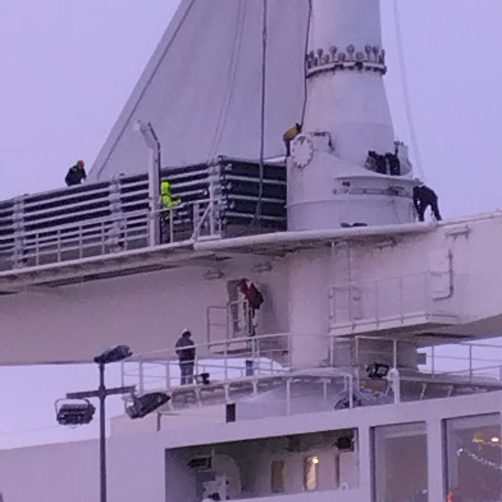 Equipage et techniciens travaillent au démontage de la voile