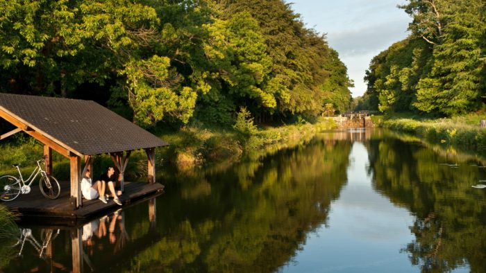 Promeneurs à vélo faisant une pause à Hédé-Bazouges (35), sur une cale de mise à l'eau au bord du canal