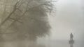 Pêcheur sur le canal à bord d'une barque dans la brume