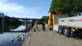 Les agents de la Région s'apprêtent à extraire un petit voilier coulé dans la Vilaine, près du quai sur la commune de Langon