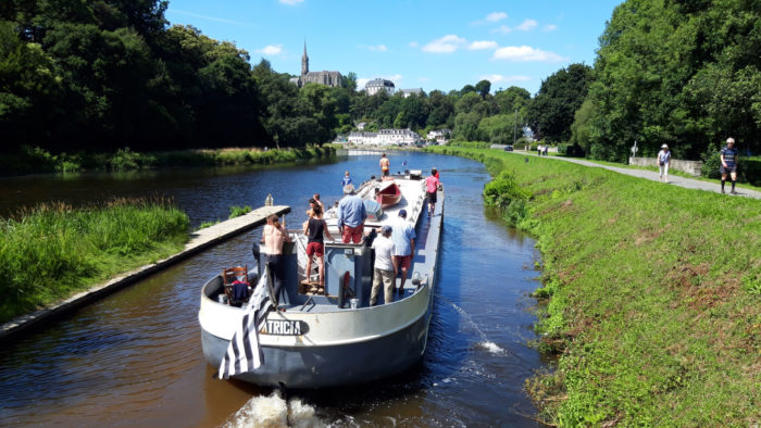 vue arrière d'une péniche de transportant des gens et arborant le drapeau breton