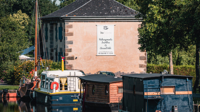 hébergements insolites dans des bateaux arrimés près d'une maison éclusière transformée en gîte et proposant un accueil vélo