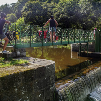 Groupes de cycliste passant au dessus d'une écluse avec leurs vélos (voir l'image en plus grand)