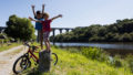 enfants avec leur vélo au pied d'un pont le long du canal