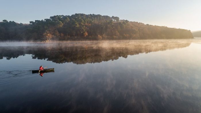 Vue drone du lac de Guerlédan avec canoé à l'automne.